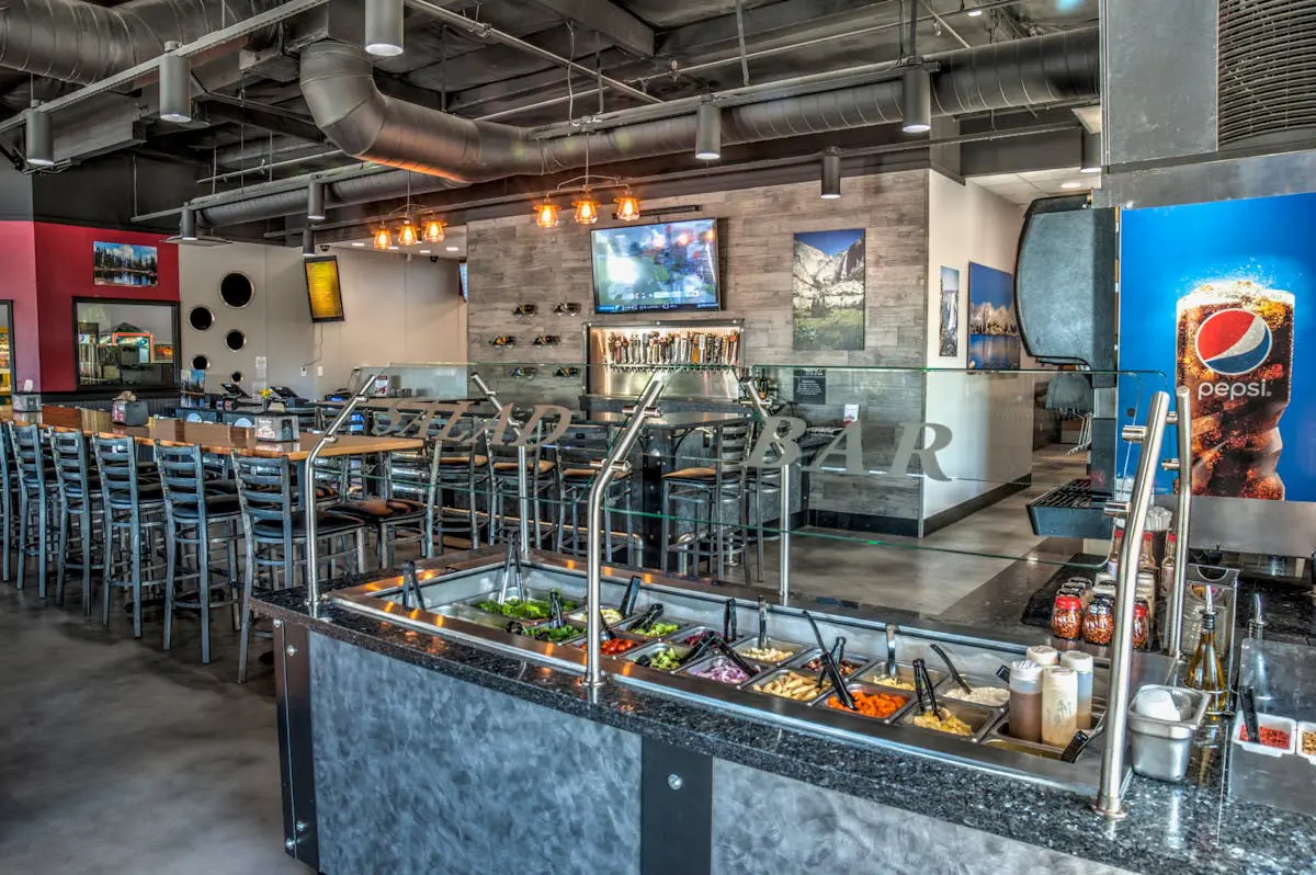 Interior of a modern restaurant with a salad bar and stylish decor.