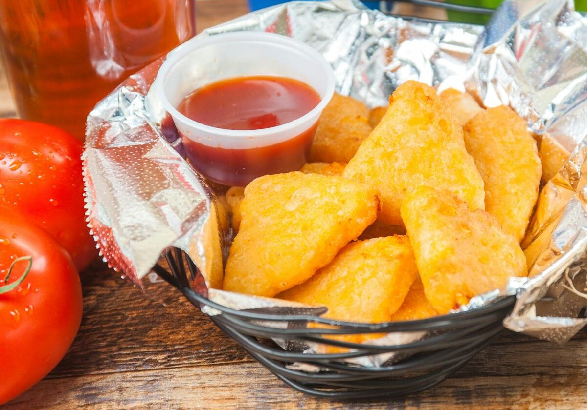 asset 12 Basket of crispy golden chicken nuggets with dipping sauce.