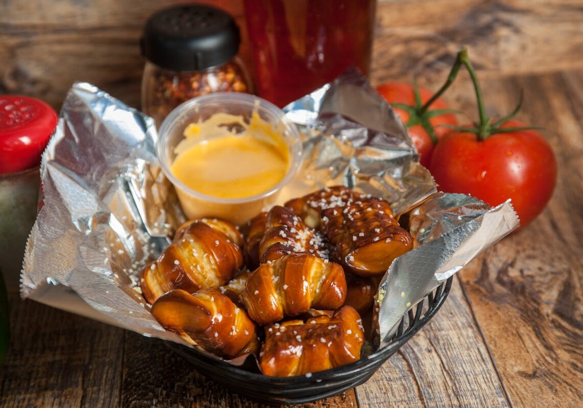 asset 15 A basket of soft pretzel bites with cheese sauce and tomatoes.