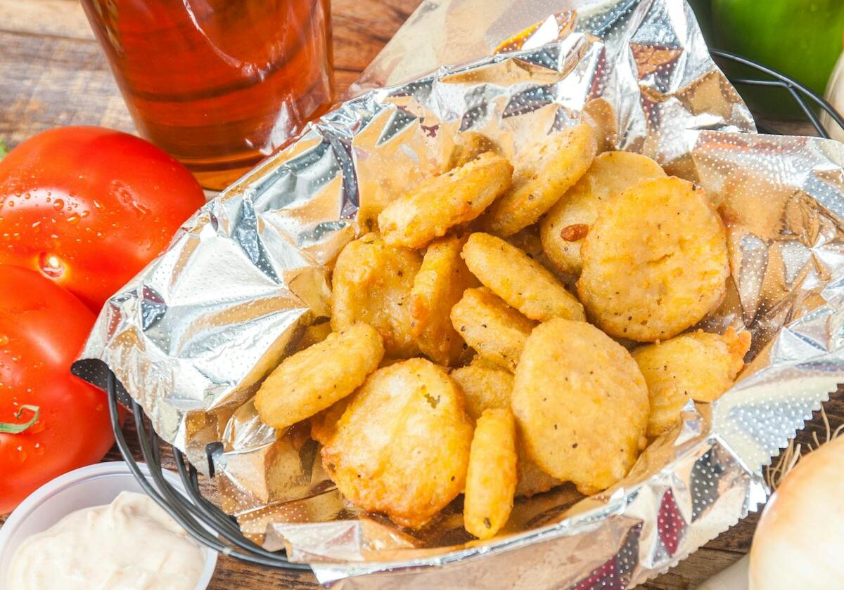 asset 17 Basket of golden fried chicken nuggets with dipping sauce.