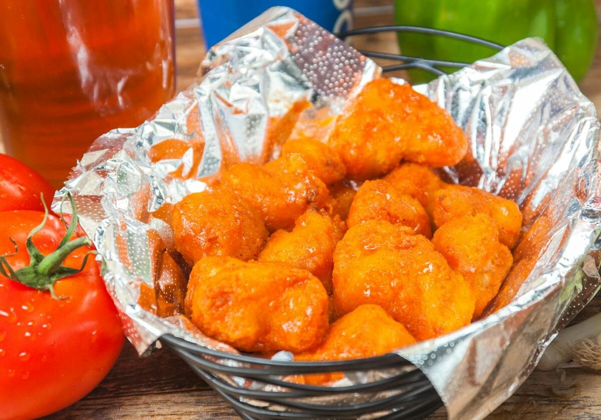 asset 19 A basket of crispy buffalo chicken wings with sauce.