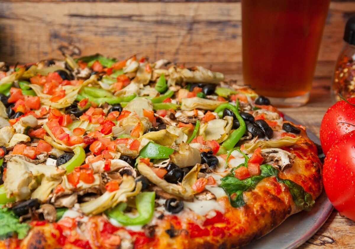 asset 25 A freshly baked vegetable pizza with a glass of beer.