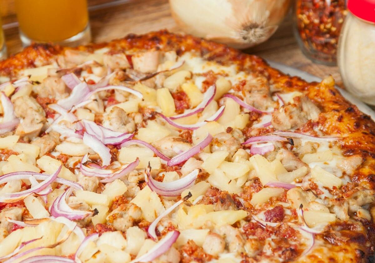 asset 28 Pizza topped with chicken, onions, and cheese.