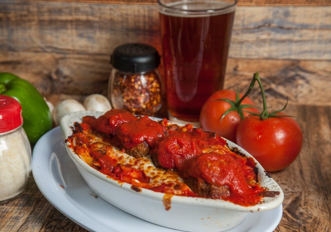 asset 45 A bowl of meatballs in marinara sauce with tomatoes and chili flakes.