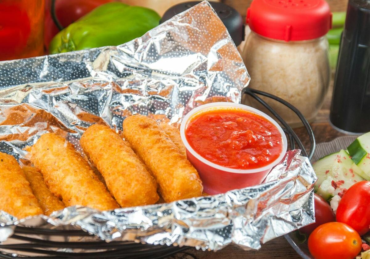asset 8 Fried mozzarella sticks with marinara sauce in foil.